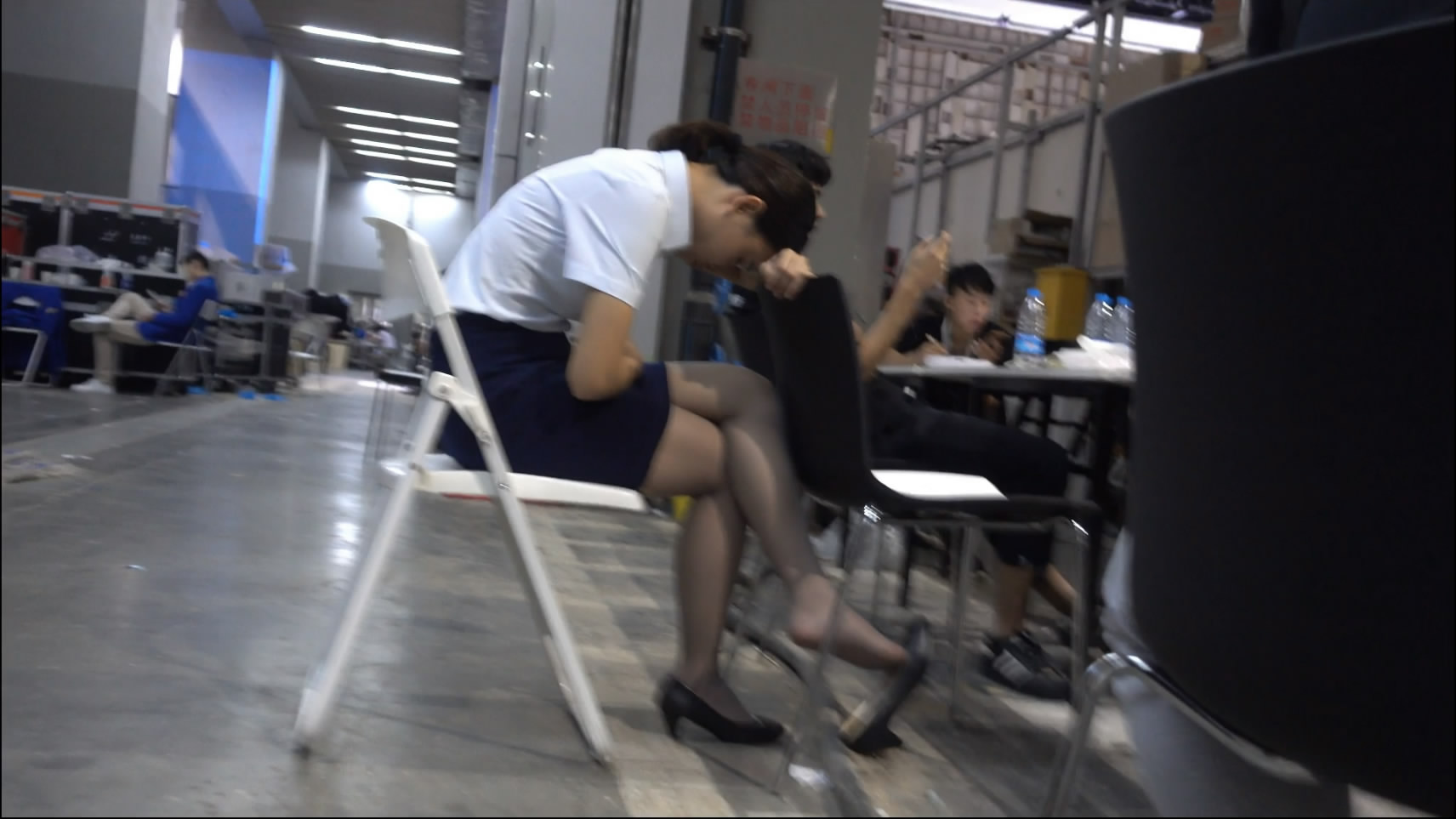 Asleep on a bench with her legs dangling